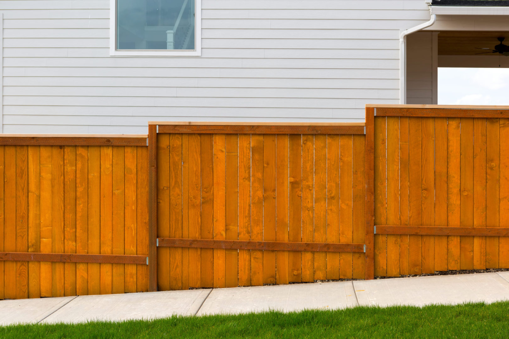 Canva New Home Backyard Red Stained Cedar Wood Fence Construction Scaled 